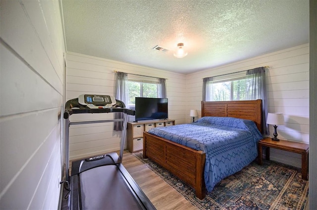 2590 Old 21 Rd, Idabel, OK 74745 - bedroom featuring a textured ceiling, wood finished floors, and wood walls