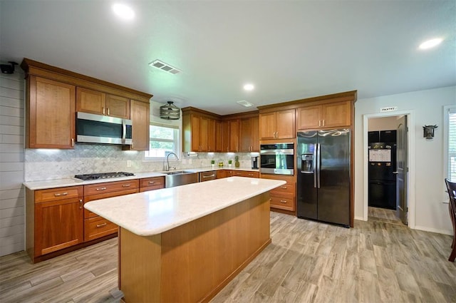 2590 Old 21 Rd, Idabel, OK 74745 - kitchen with appliances with stainless steel finishes, a sink, light wood finished floors, and brown cabinetry