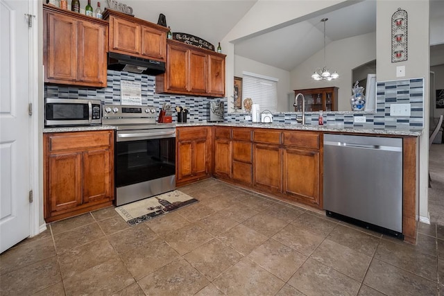 1528 Fawn Run Xing, Norman, OK 73071 - kitchen featuring stainless steel appliances, under cabinet range hood, lofted ceiling, a chandelier, and decorative backsplash