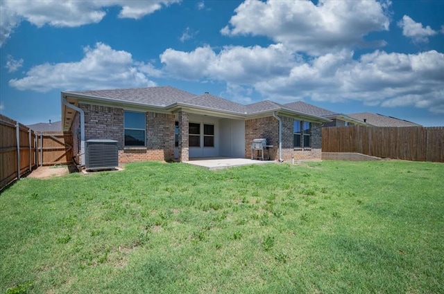 12824 NW 4th Ter, Yukon, OK 73099 - back of property featuring central AC unit, a patio area, and brick siding