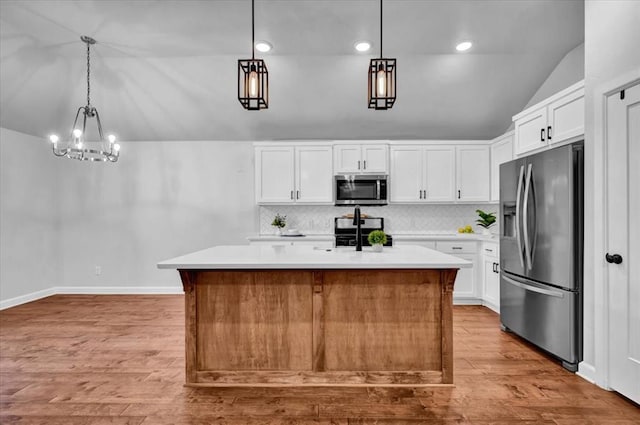 12824 NW 4th Ter, Yukon, OK 73099 - kitchen featuring appliances with stainless steel finishes, vaulted ceiling, light countertops, light wood-type flooring, and tasteful backsplash