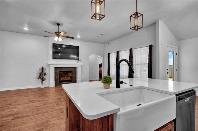 12824 NW 4th Ter, Yukon, OK 73099 - kitchen featuring dishwasher, a sink, open floor plan, light countertops, and light wood-type flooring