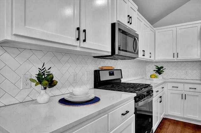 12824 NW 4th Ter, Yukon, OK 73099 - kitchen featuring range with gas stovetop, stainless steel microwave, white cabinets, vaulted ceiling, and tasteful backsplash