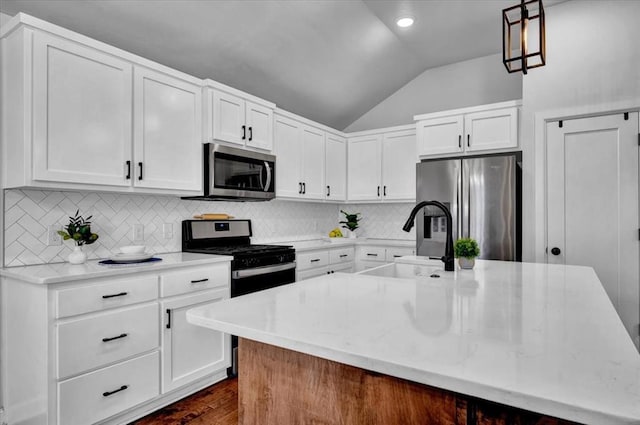 12824 NW 4th Ter, Yukon, OK 73099 - kitchen with stainless steel appliances, vaulted ceiling, a sink, an island with sink, and white cabinets