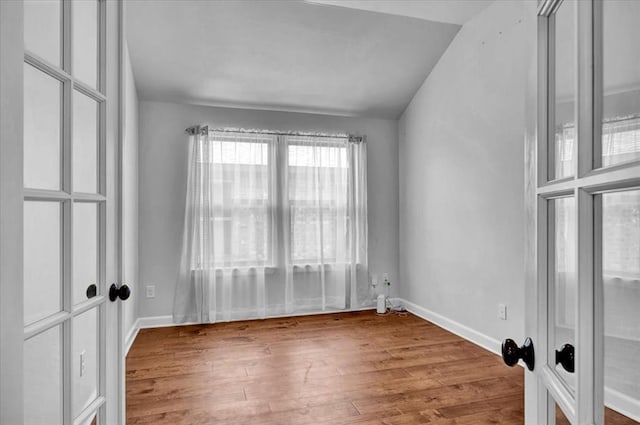 12824 NW 4th Ter, Yukon, OK 73099 - spare room featuring wood finished floors, baseboards, and vaulted ceiling
