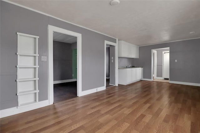 6017 Pat Ave, Oklahoma City, OK 73149 - unfurnished living room with wood finished floors, crown molding, and baseboards