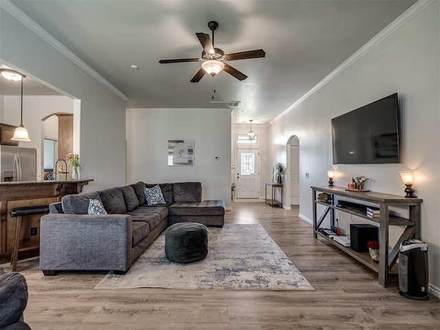 12005 NW 139th St, Piedmont, OK 73078 - living area with arched walkways, a ceiling fan, ornamental molding, wood finished floors, and baseboards