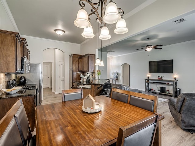 12005 NW 139th St, Piedmont, OK 73078 - dining area with arched walkways, light wood-type flooring, ceiling fan, crown molding, and a chandelier