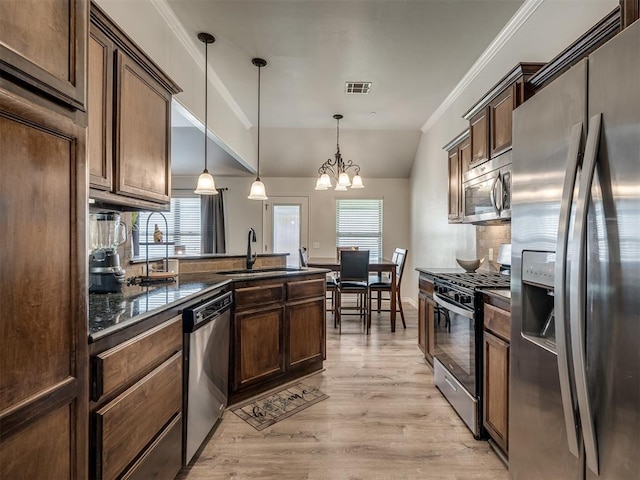 12005 NW 139th St, Piedmont, OK 73078 - kitchen with appliances with stainless steel finishes, a sink, dark countertops, a chandelier, and healthy amount of natural light
