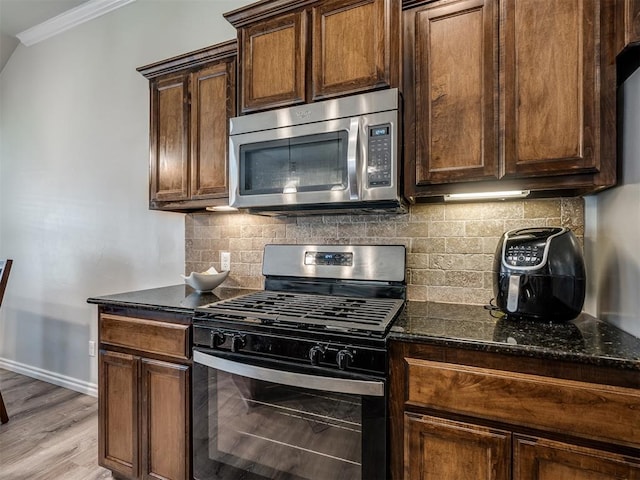 12005 NW 139th St, Piedmont, OK 73078 - kitchen with stainless steel appliances, ornamental molding, dark stone counters, baseboards, and backsplash