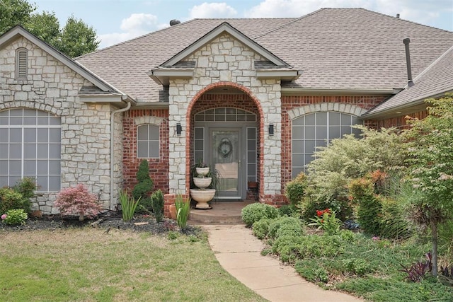 1701 Tifton Dr, Edmond, OK 73012 - view of front of property with stone siding, roof with shingles, brick siding, and a front yard