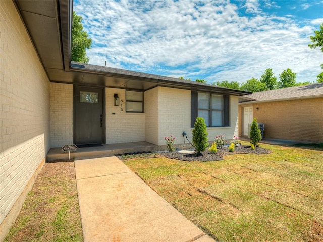 813 Branchwood Ct, Norman, OK 73072 - view of exterior entry featuring brick siding and a yard