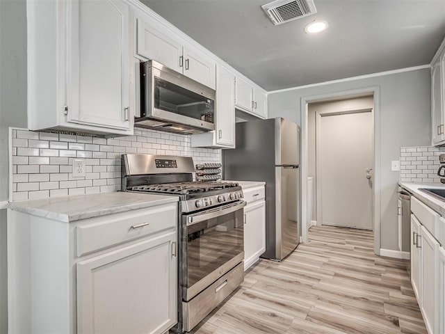 813 Branchwood Ct, Norman, OK 73072 - kitchen featuring stainless steel appliances, tasteful backsplash, white cabinetry, light wood-style floors, and recessed lighting
