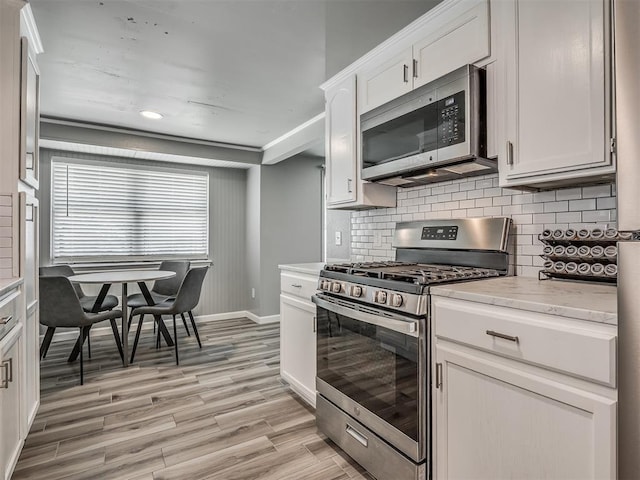 813 Branchwood Ct, Norman, OK 73072 - kitchen featuring stainless steel appliances, baseboards, backsplash, light wood finished floors, and white cabinets