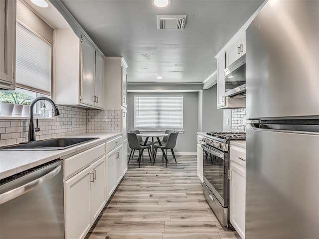 813 Branchwood Ct, Norman, OK 73072 - kitchen featuring appliances with stainless steel finishes, a sink, light countertops, backsplash, and recessed lighting