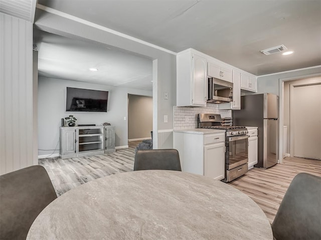 813 Branchwood Ct, Norman, OK 73072 - kitchen with stainless steel appliances, light wood finished floors, white cabinetry, tasteful backsplash, and recessed lighting