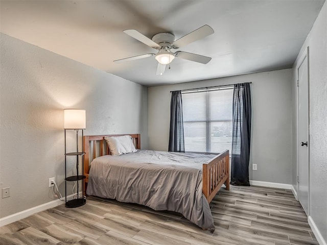 813 Branchwood Ct, Norman, OK 73072 - bedroom with wood finished floors, baseboards, a ceiling fan, and a textured wall