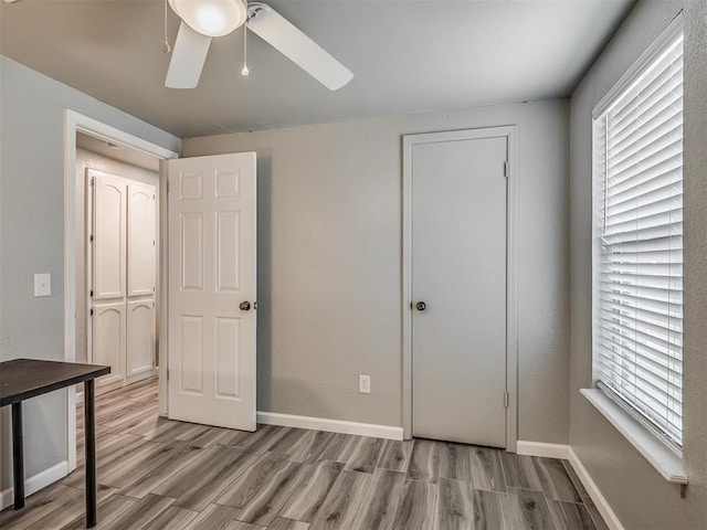 813 Branchwood Ct, Norman, OK 73072 - unfurnished bedroom featuring wood finished floors, baseboards, and multiple windows
