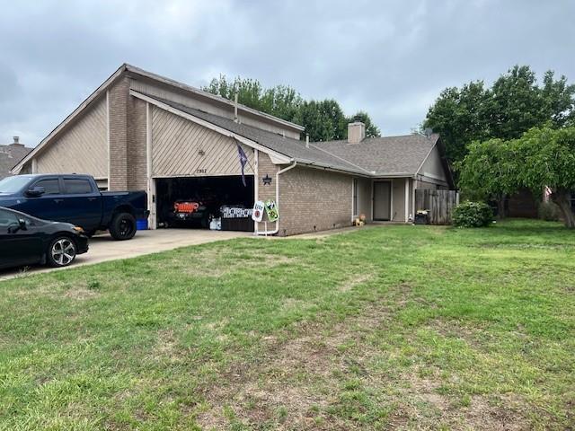7905 Debar Cir, Oklahoma City, OK 73132 - view of property exterior featuring a garage, a chimney, driveway, and brick siding