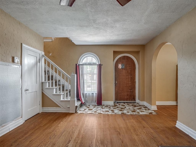1132 SW 25th St, Oklahoma City, OK 73109 - foyer featuring wood finished floors, arched walkways, a textured ceiling, stairway, and a textured wall