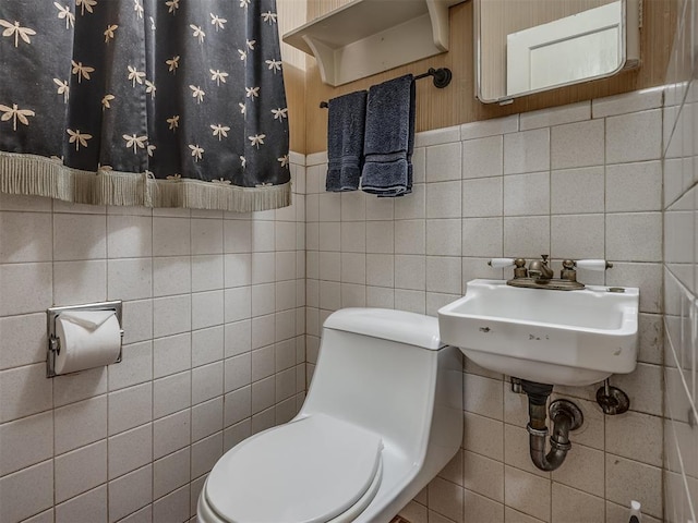 1132 SW 25th St, Oklahoma City, OK 73109 - bathroom with tile walls, toilet, and a sink