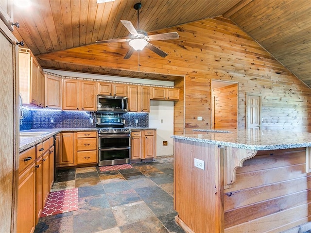 kitchen with appliances with stainless steel finishes, tasteful backsplash, vaulted ceiling, wood ceiling, and wooden walls