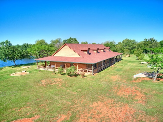 rear view of house featuring a yard and a water view