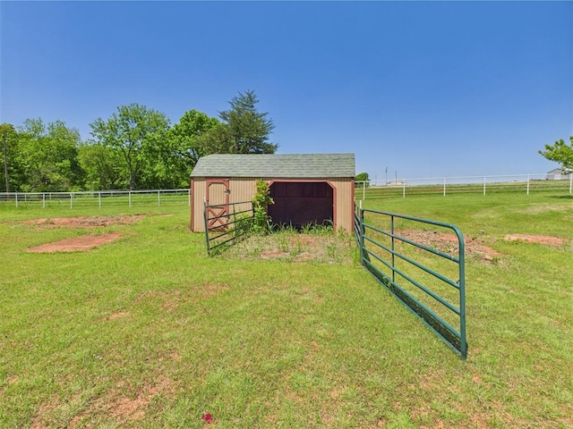 view of yard featuring an outdoor structure, a view of rural / pastoral area, and an outbuilding
