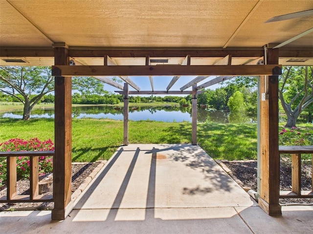 view of patio with a water view and a pergola