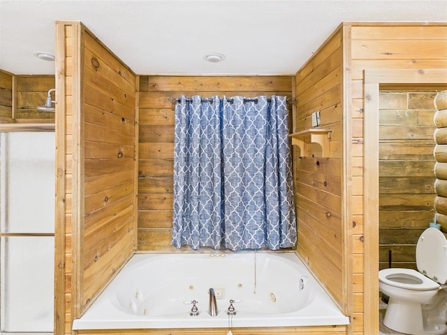 full bathroom with a tub with jets, toilet, and wooden walls