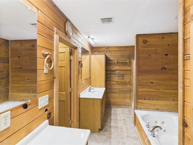 full bath featuring wood walls, a jetted tub, and vanity