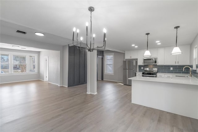 1925 NW 36th St, Oklahoma City, OK 73118 - kitchen with appliances with stainless steel finishes, a sink, open floor plan, a chandelier, and light countertops