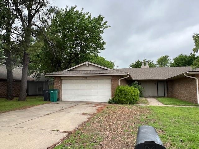 7909 Harvest Moon Rd, Oklahoma City, OK 73132 - ranch-style house featuring an attached garage, brick siding, driveway, a front yard, and a chimney