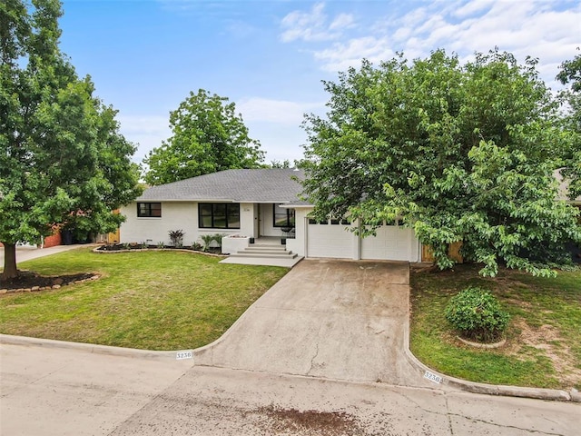 3236 NW 68th St, Oklahoma City, OK 73116 - ranch-style home with driveway, a front lawn, an attached garage, and stucco siding