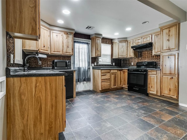 922 W 7th St, Stroud, OK 74079 - kitchen with black appliances, under cabinet range hood, dark countertops, a sink, and backsplash
