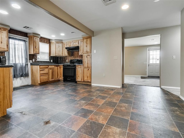 922 W 7th St, Stroud, OK 74079 - kitchen with black gas range oven, baseboards, dark countertops, under cabinet range hood, and tasteful backsplash