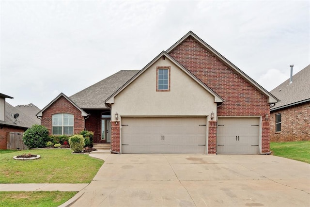traditional-style house with driveway, brick siding, a front yard, stucco siding, and an attached garage