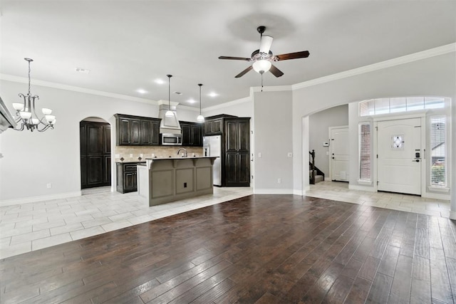 kitchen featuring appliances with stainless steel finishes, open floor plan, arched walkways, a chandelier, and ceiling fan
