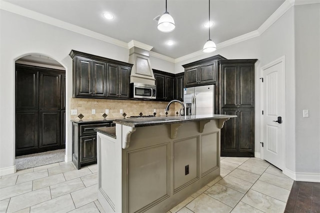 kitchen featuring appliances with stainless steel finishes, a kitchen breakfast bar, backsplash, crown molding, and pendant lighting