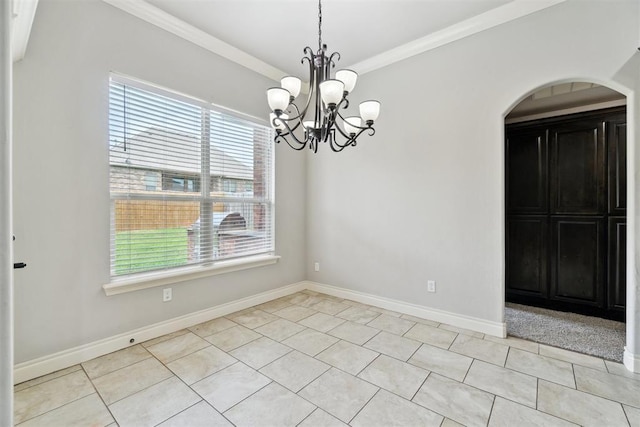 unfurnished dining area with plenty of natural light, a chandelier, crown molding, arched walkways, and baseboards