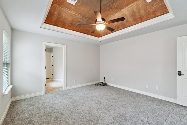 unfurnished room with carpet floors, a raised ceiling, ceiling fan, and baseboards
