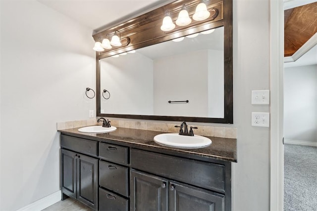 bathroom with baseboards and double vanity