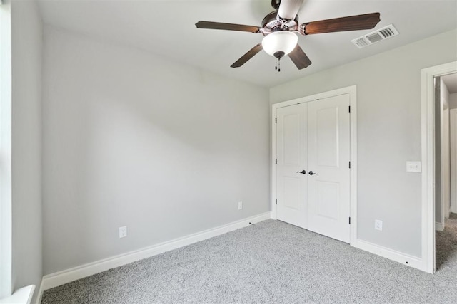 unfurnished bedroom featuring carpet flooring, a closet, baseboards, and a ceiling fan