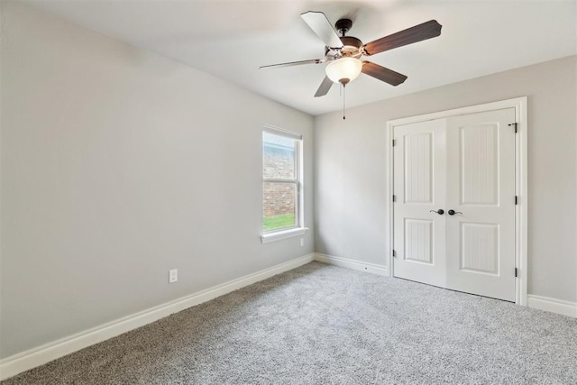 unfurnished bedroom with carpet flooring, baseboards, a closet, and ceiling fan