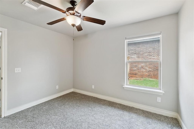 carpeted spare room featuring a ceiling fan and baseboards