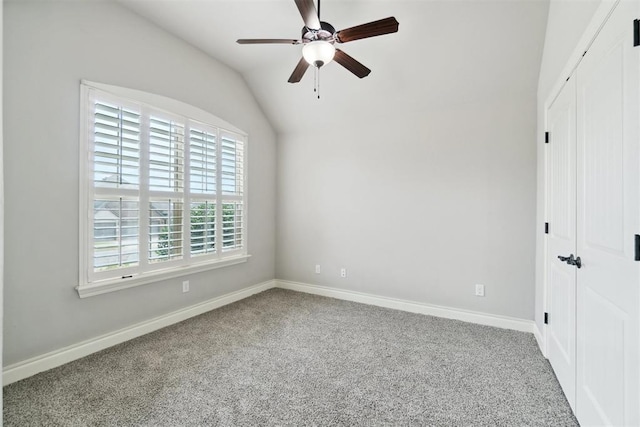 unfurnished bedroom with multiple windows, lofted ceiling, carpet floors, baseboards, and a closet