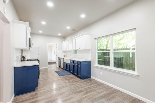 1717 N Kelham Ave, Oklahoma City, OK 73111 - kitchen with blue cabinets, appliances with stainless steel finishes, baseboards, light countertops, and recessed lighting