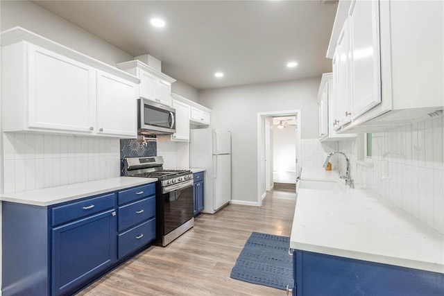 1717 N Kelham Ave, Oklahoma City, OK 73111 - kitchen with appliances with stainless steel finishes, blue cabinets, tasteful backsplash, light wood-type flooring, and light countertops