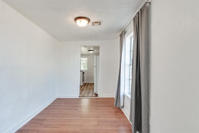 hallway featuring light wood-type flooring and baseboards