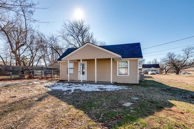 bungalow featuring a shingled roof, fence, and a porch